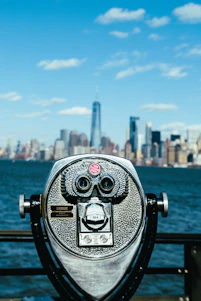 gray tower viewer facing the ocean and city during day