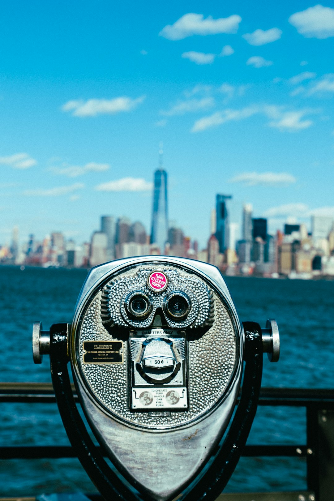 gray tower viewer facing the ocean and city during day