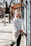 a woman leaning against a building on a sidewalk