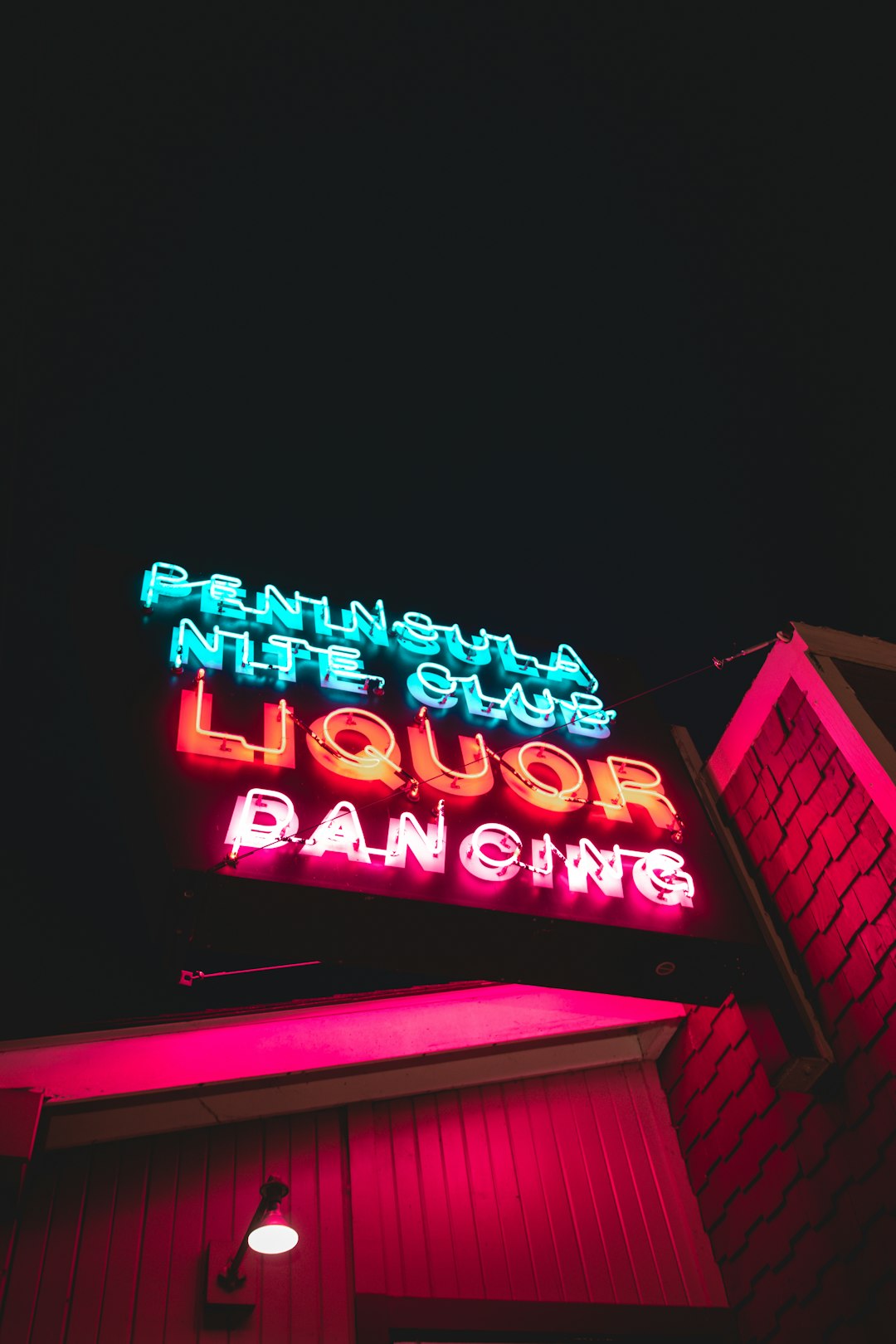 blue and red Peninsula Night Club Liquor Dancing neon light signage