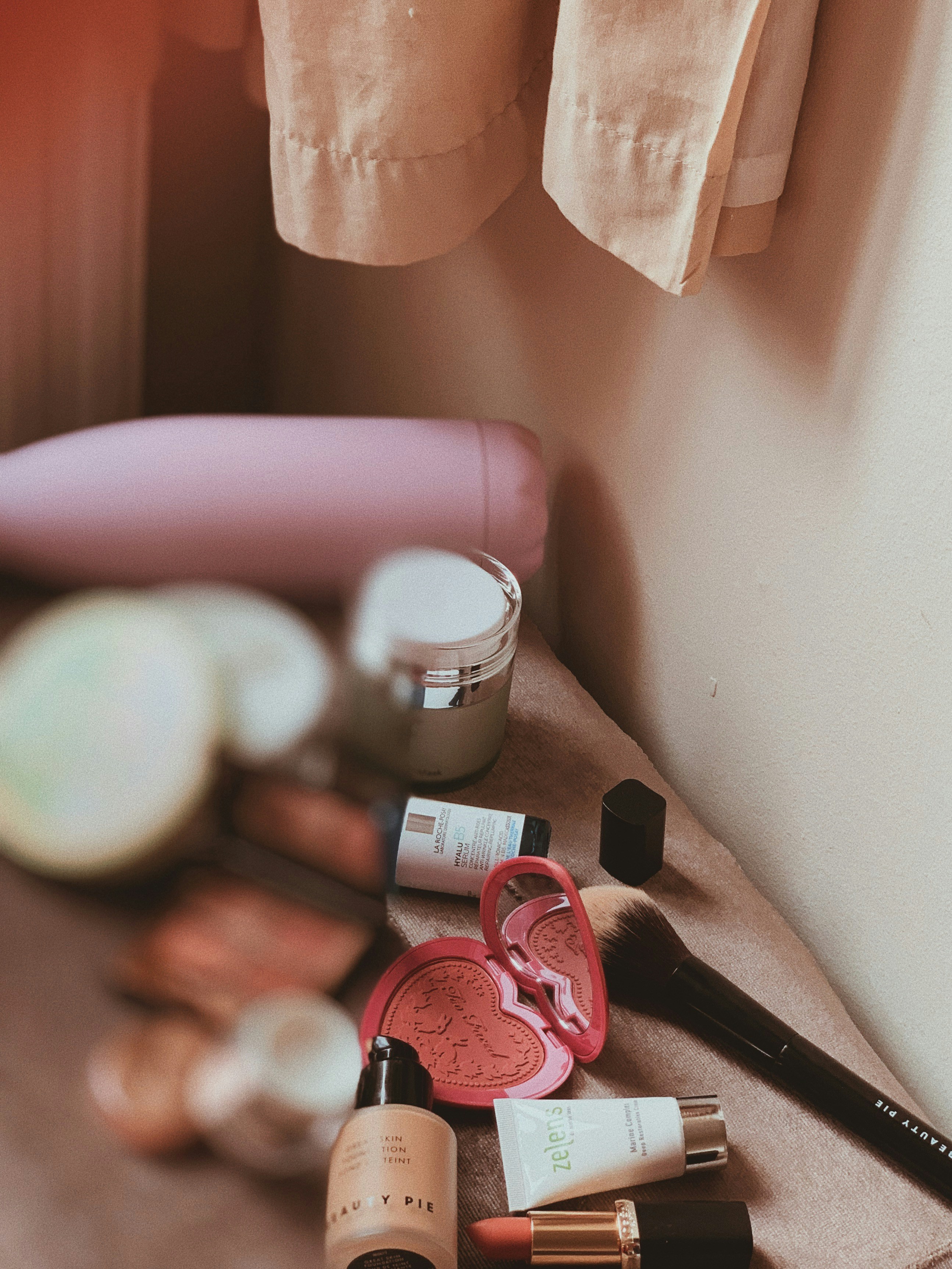 Luxury skincare products flat lay on cream linen surface, soft natural daylight