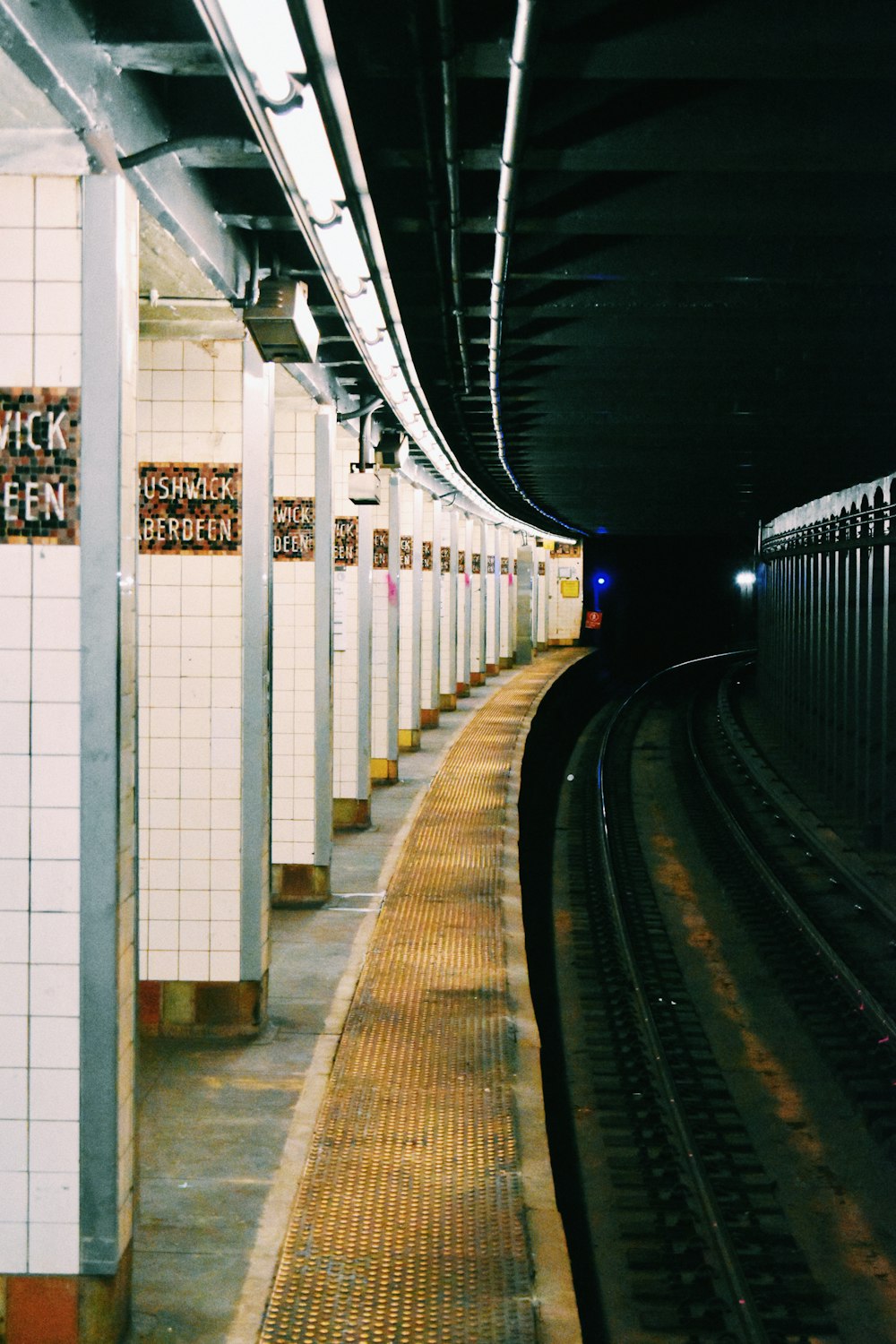 a train traveling through a train station next to a loading platform