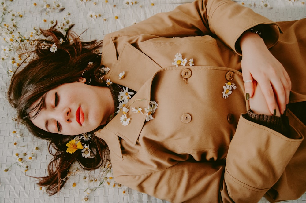 woman wearing brown coat sleeping on white surface