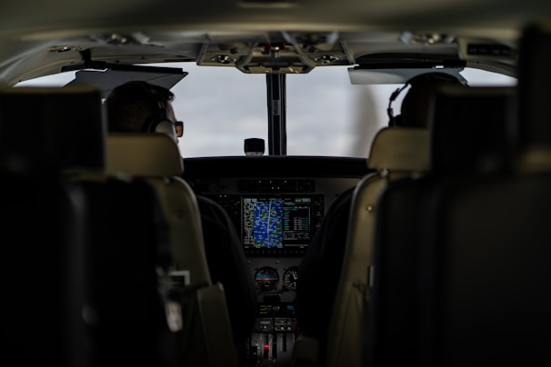 An instructor and student pilot reviewing flight plans inside the cockpit before takeoff.