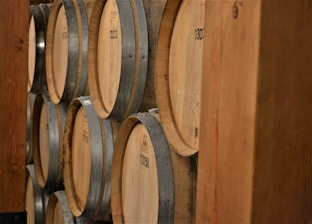 Close-up of shiny stainless steel barrels stacked neatly in a warehouse.