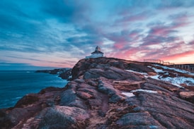 house above cliff beside shore