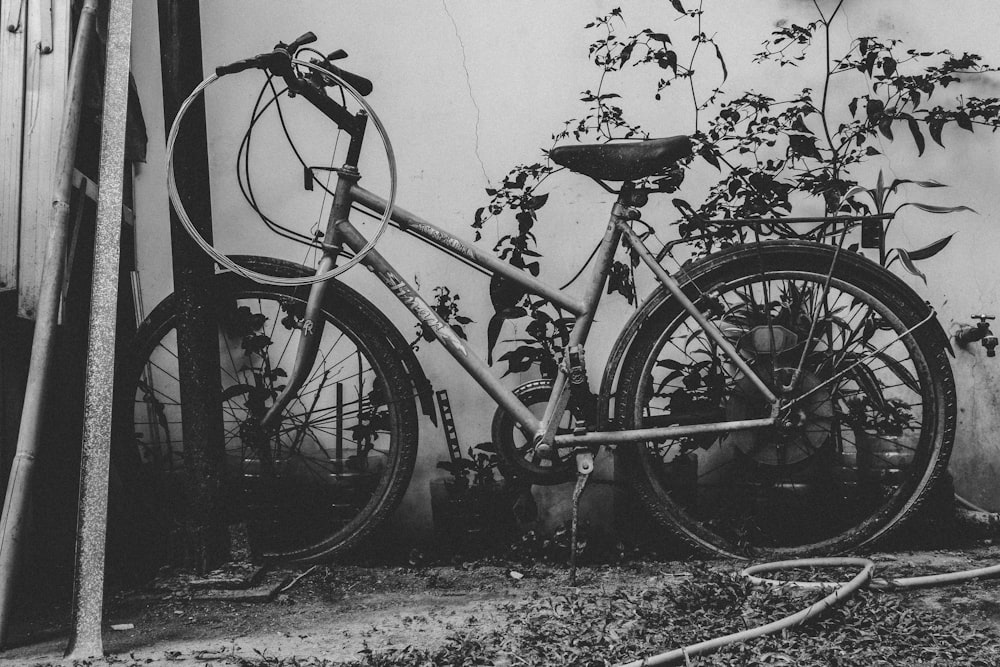 grayscale photography of commuter bike learned on metal post