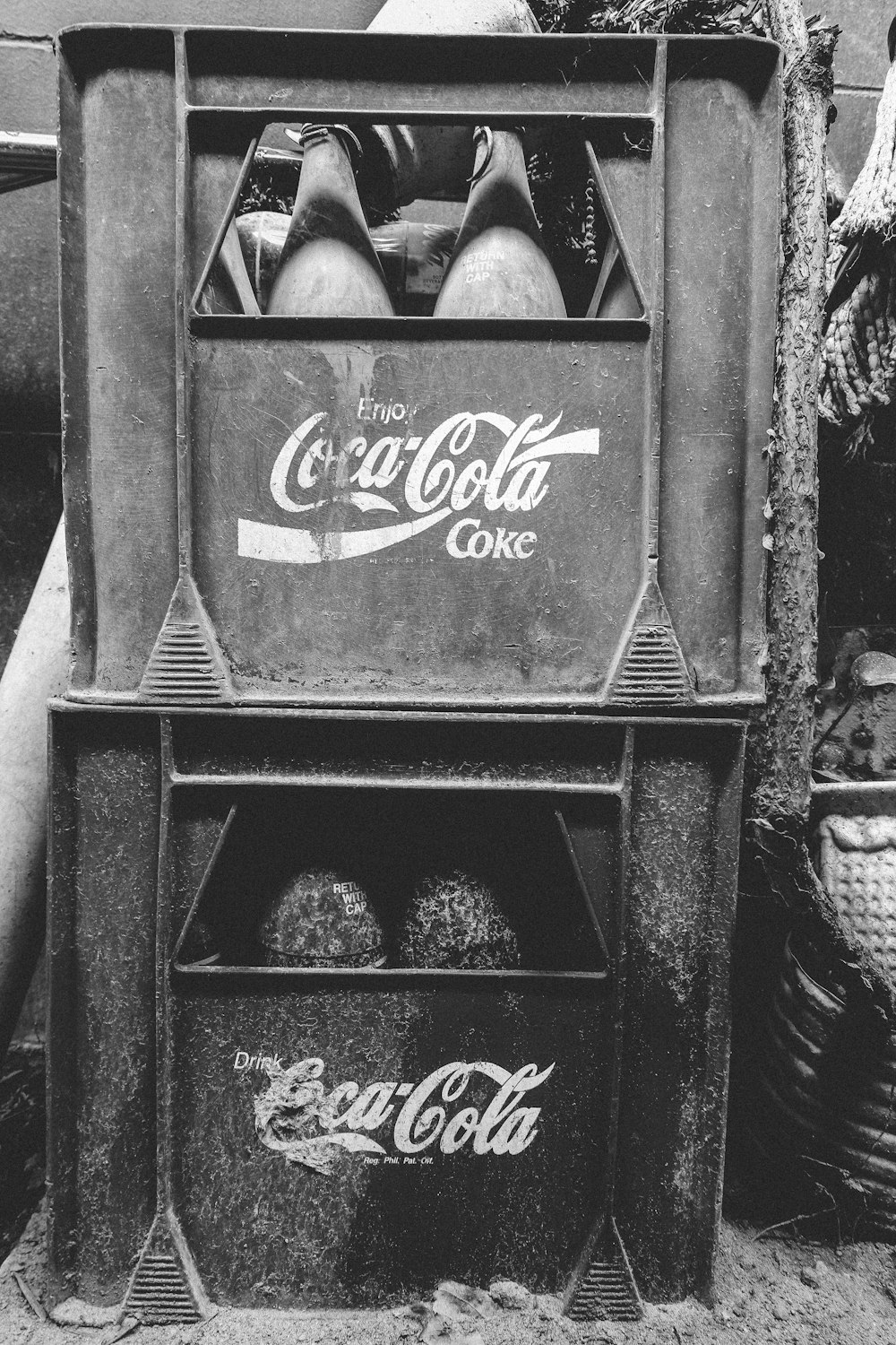 grayscale photo of staked Coca-cola crates