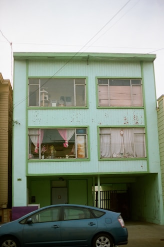 blue sedan and blue concrete building