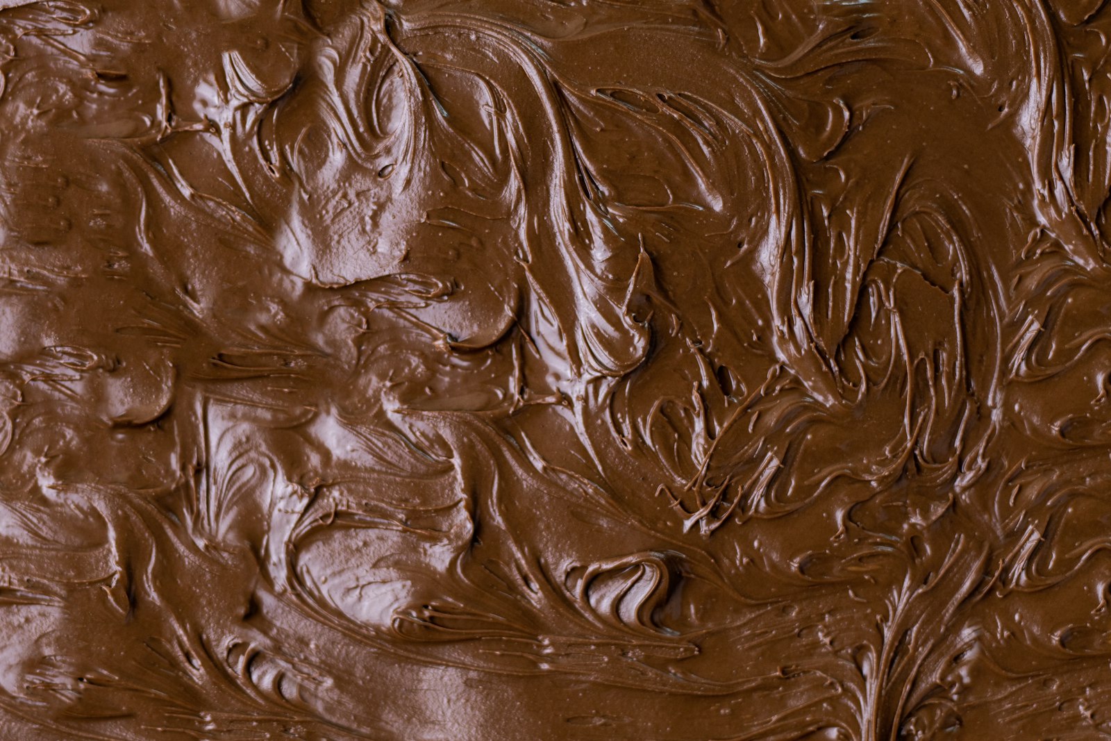 Texture lisse de chocolat fondu, illustrant la sensibilité du produit à l'humidité