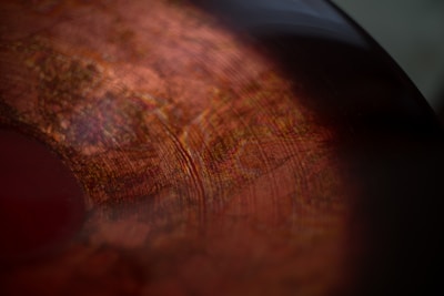 Minimalist close-up of textured vinyl record reflecting premium sound quality.