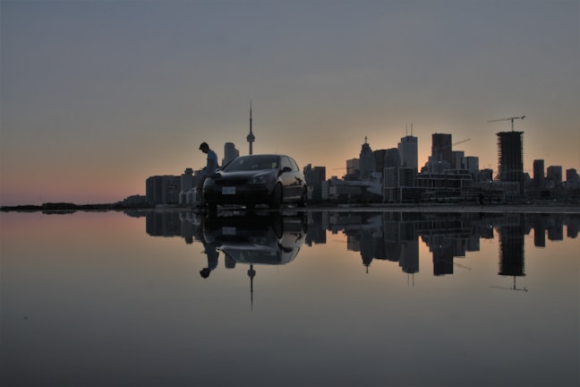Night view of Miami skyline with a City Transfers car parked nearby.