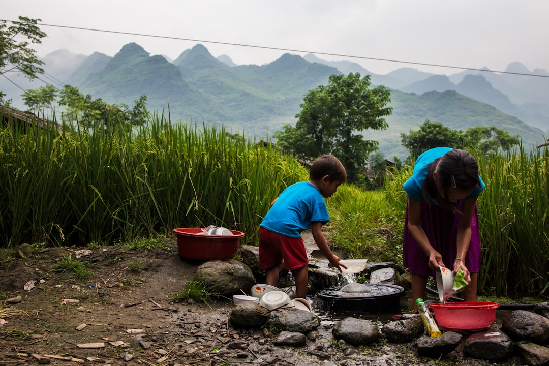 girl and boy washing clothes outdoor