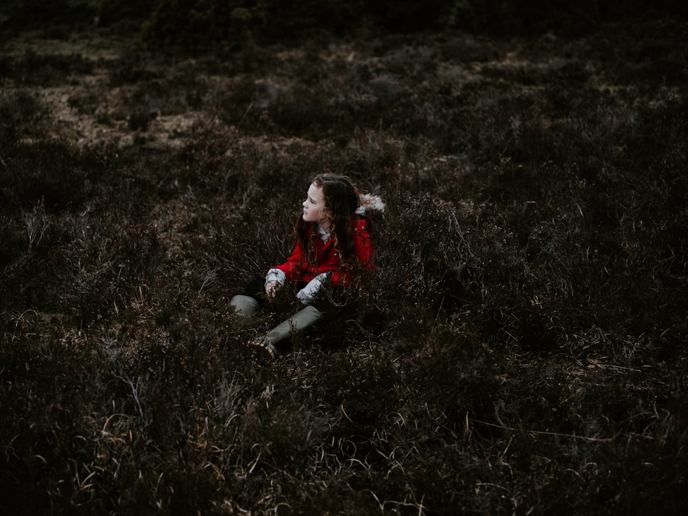 girl sitting on grass field