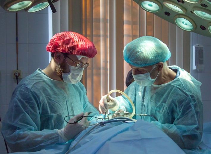 two men wearing blue lab coats