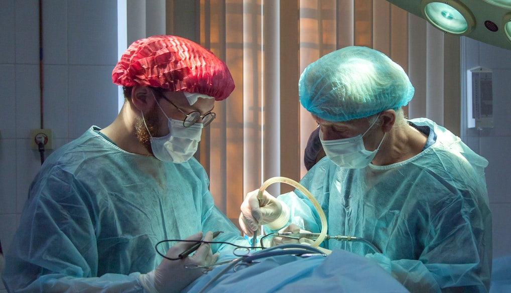 two men wearing blue lab coats