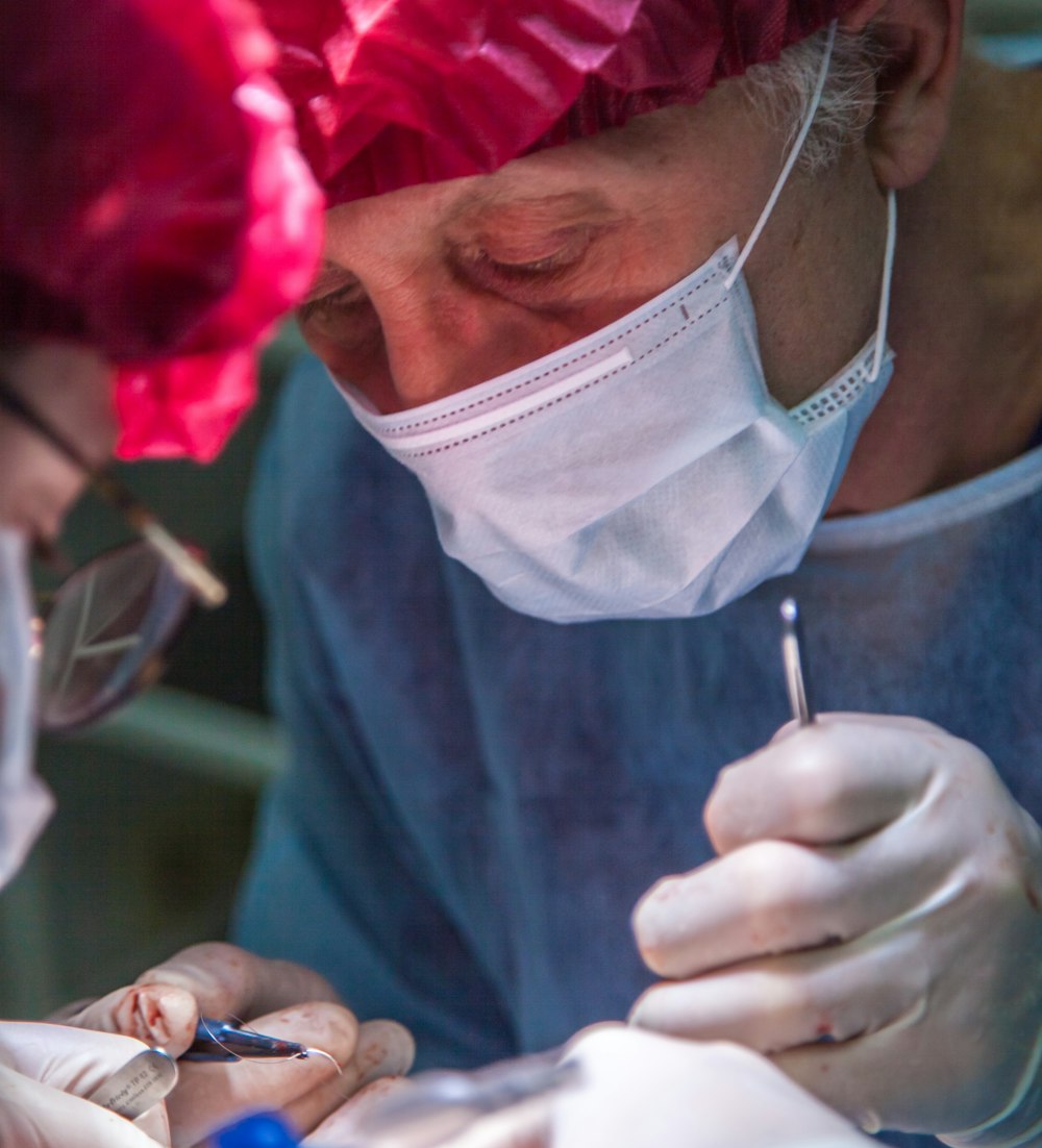 surgeon wearing white mask and pink hat