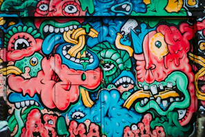 A vibrant street mural bursting with colorful abstract shapes and lively characters.