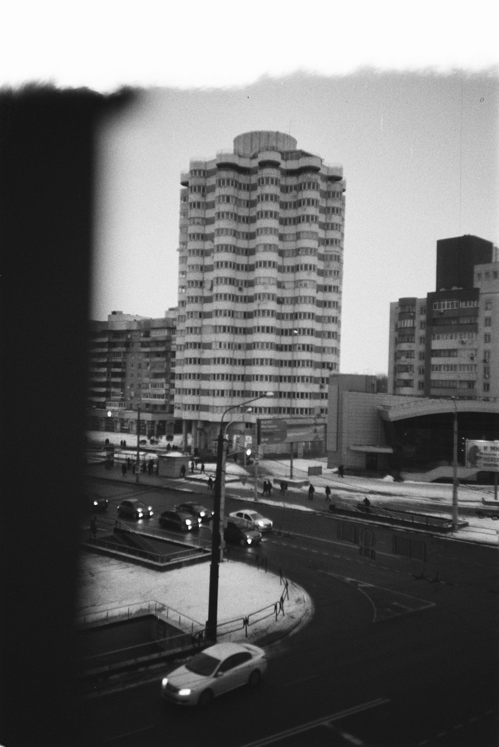 grayscale photography of vehicle beside buildings