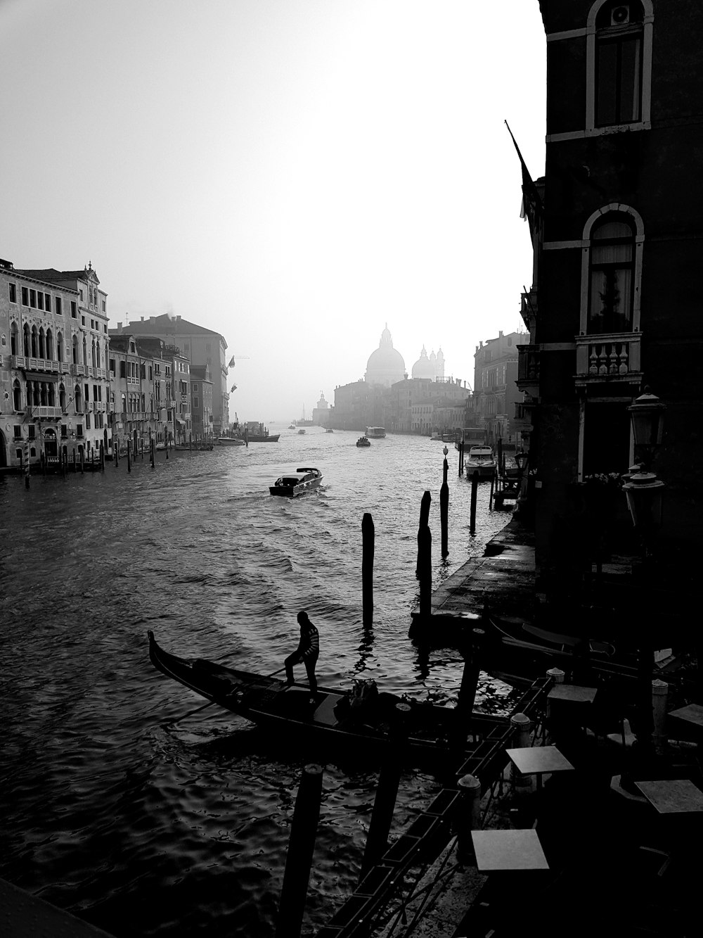 grayscale photography of body of water beside buildings