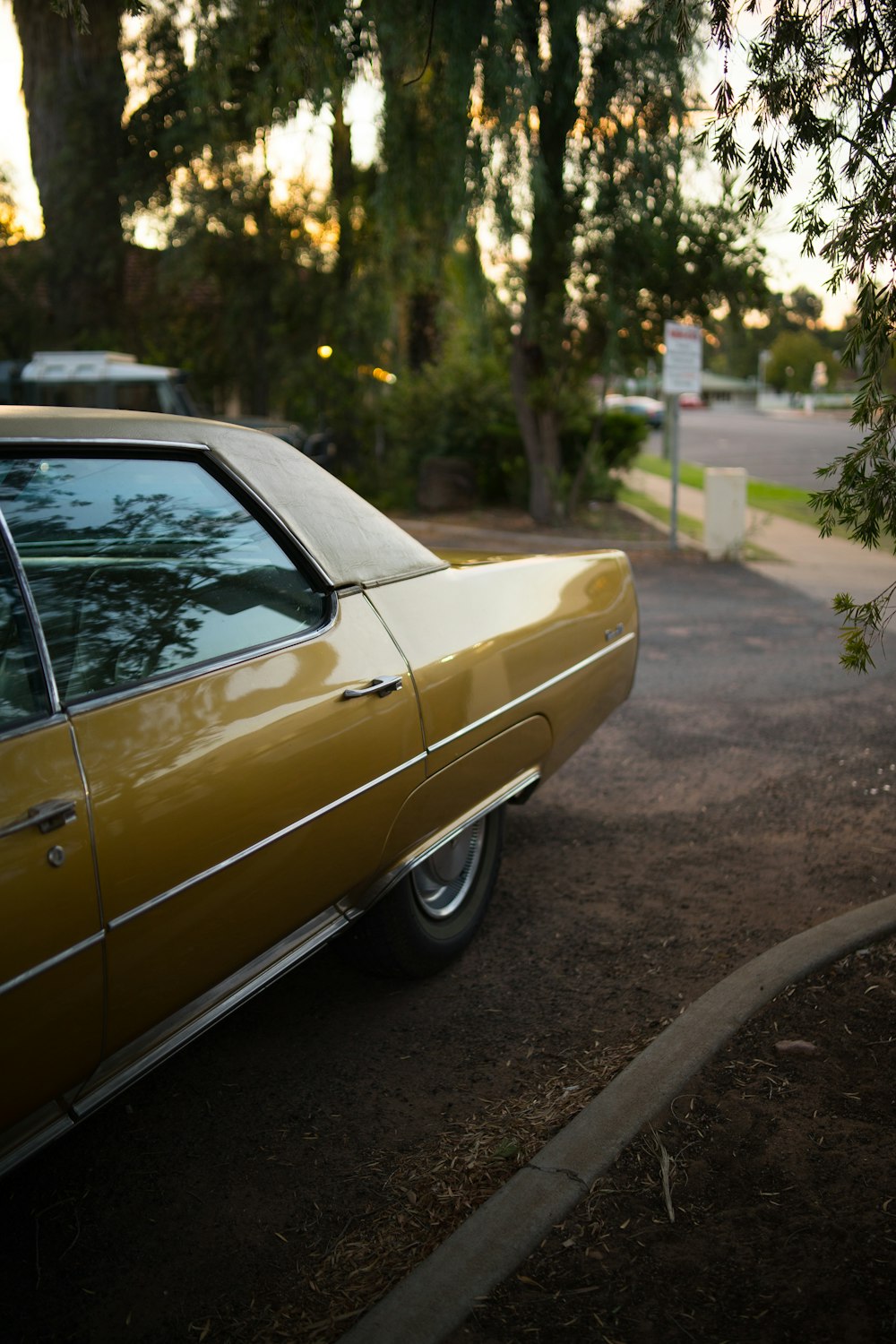 vintage yellow car hard top on park under treea