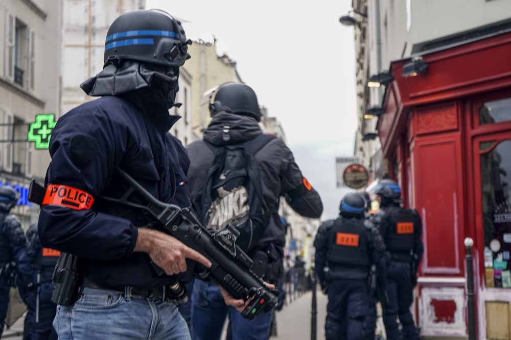 Police wearing black helmets and holding guns