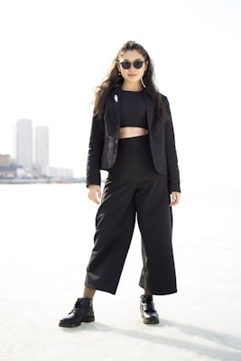 A confident woman posing in stylish, bold fashion outdoors