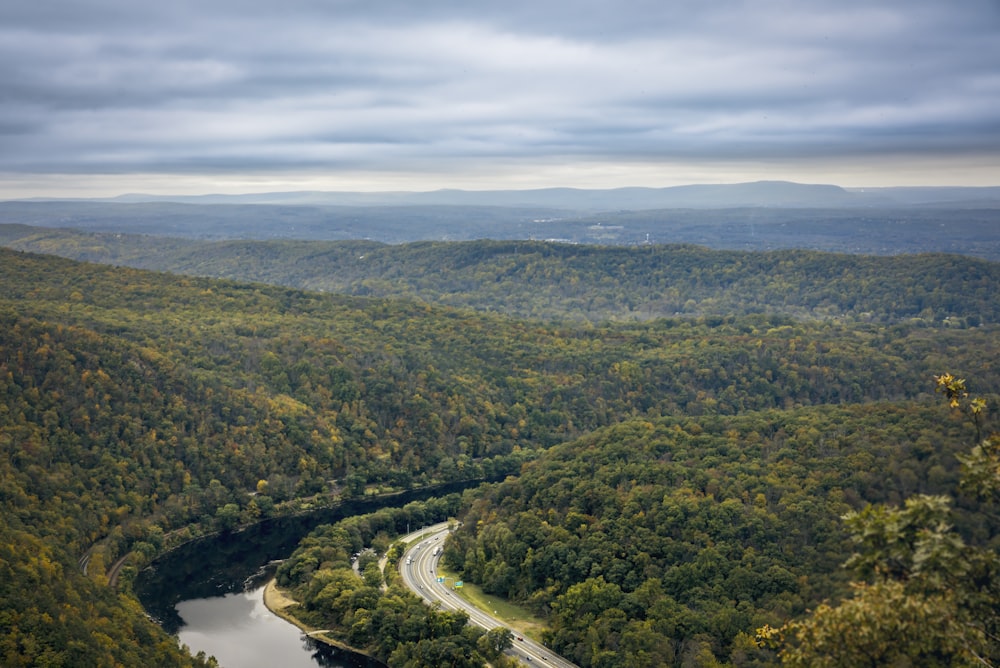 river surrounded by trees under dramatic clouds during daytime