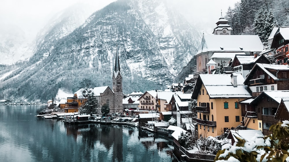 houses near body of water and mountain during daytime