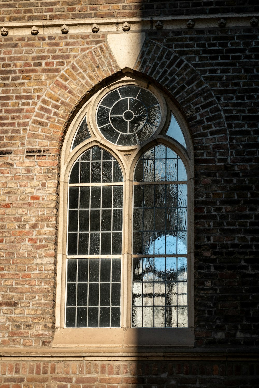 double-door white framed clear glass window with brown brick wall