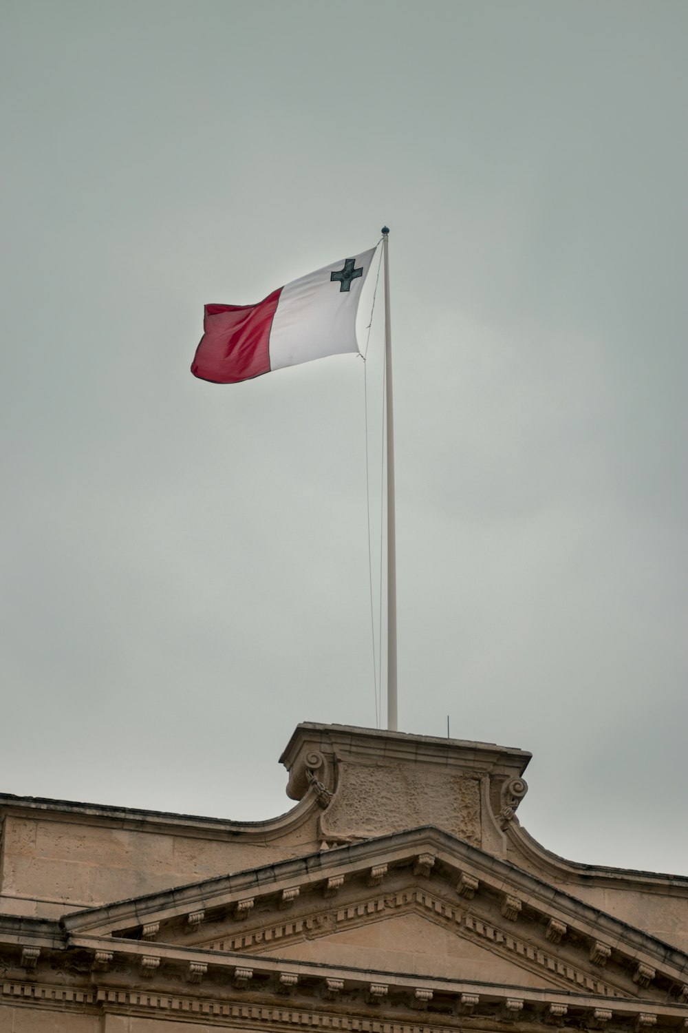 white and red flag under grey clouds