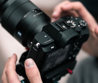 person holding black DSLR camera