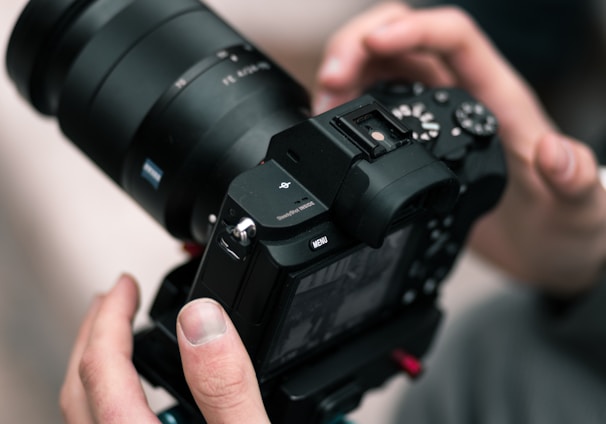 person holding black DSLR camera