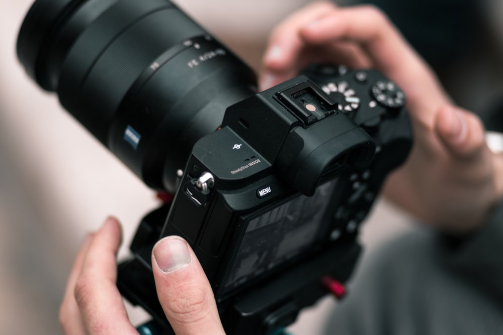 person holding black DSLR camera