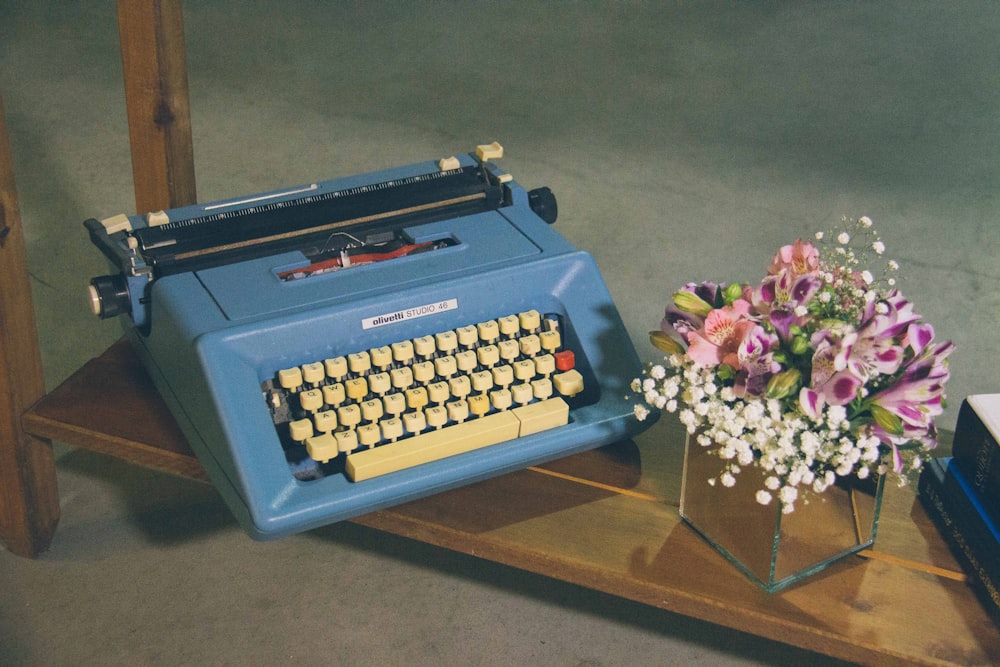 blue typewriter on brown wooden table