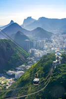 The illuminated Metrocable gliding over lush green mountains, connecting neighborhoods with the city center.