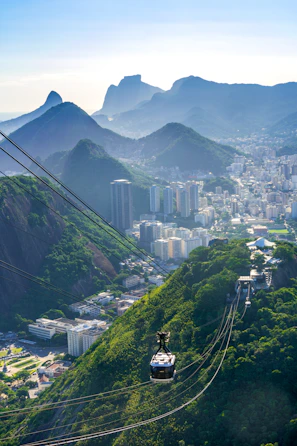 The illuminated Metrocable gliding over lush green mountains, connecting neighborhoods with the city center.