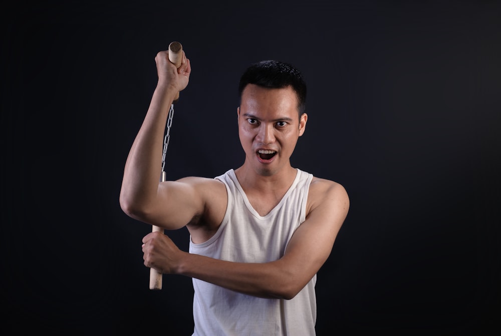 man holding brown nunchaku