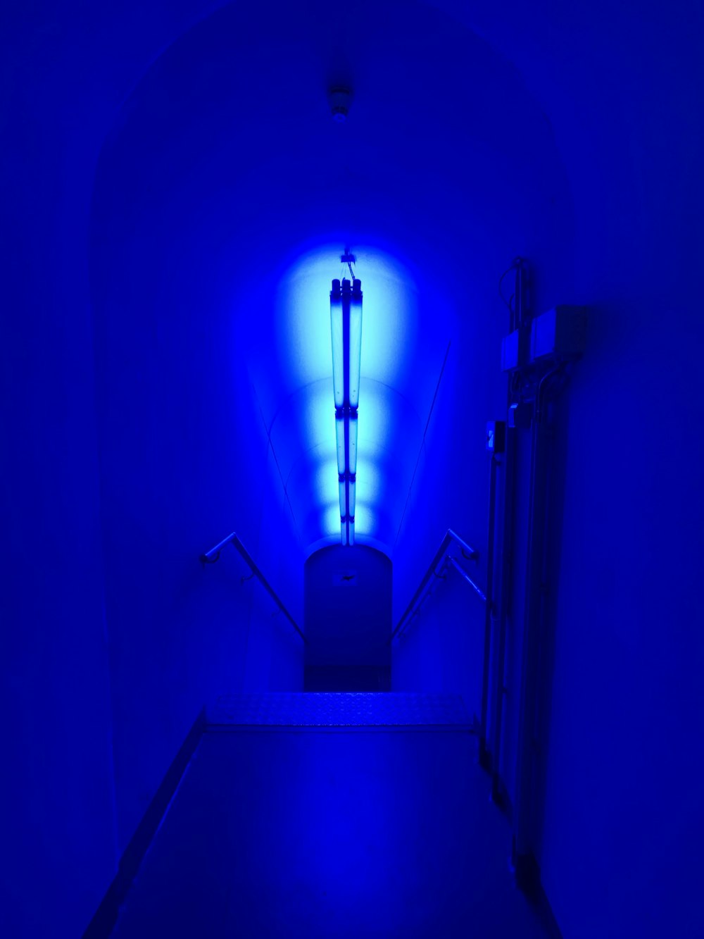 a dark hallway with a blue light in the corner