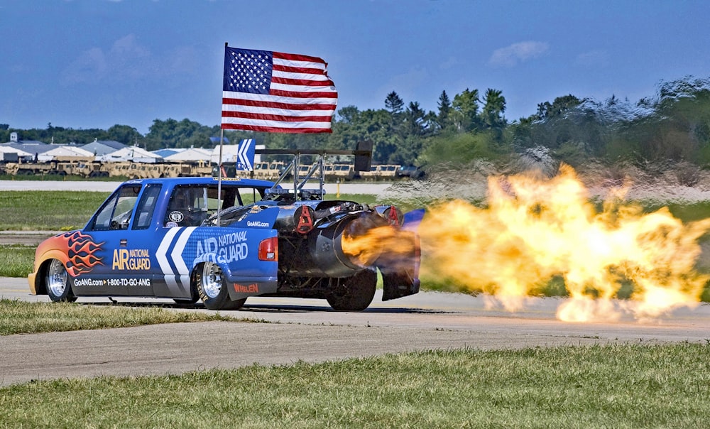 blue extra cab pickup truck with jet turbine blowing fire during daytime
