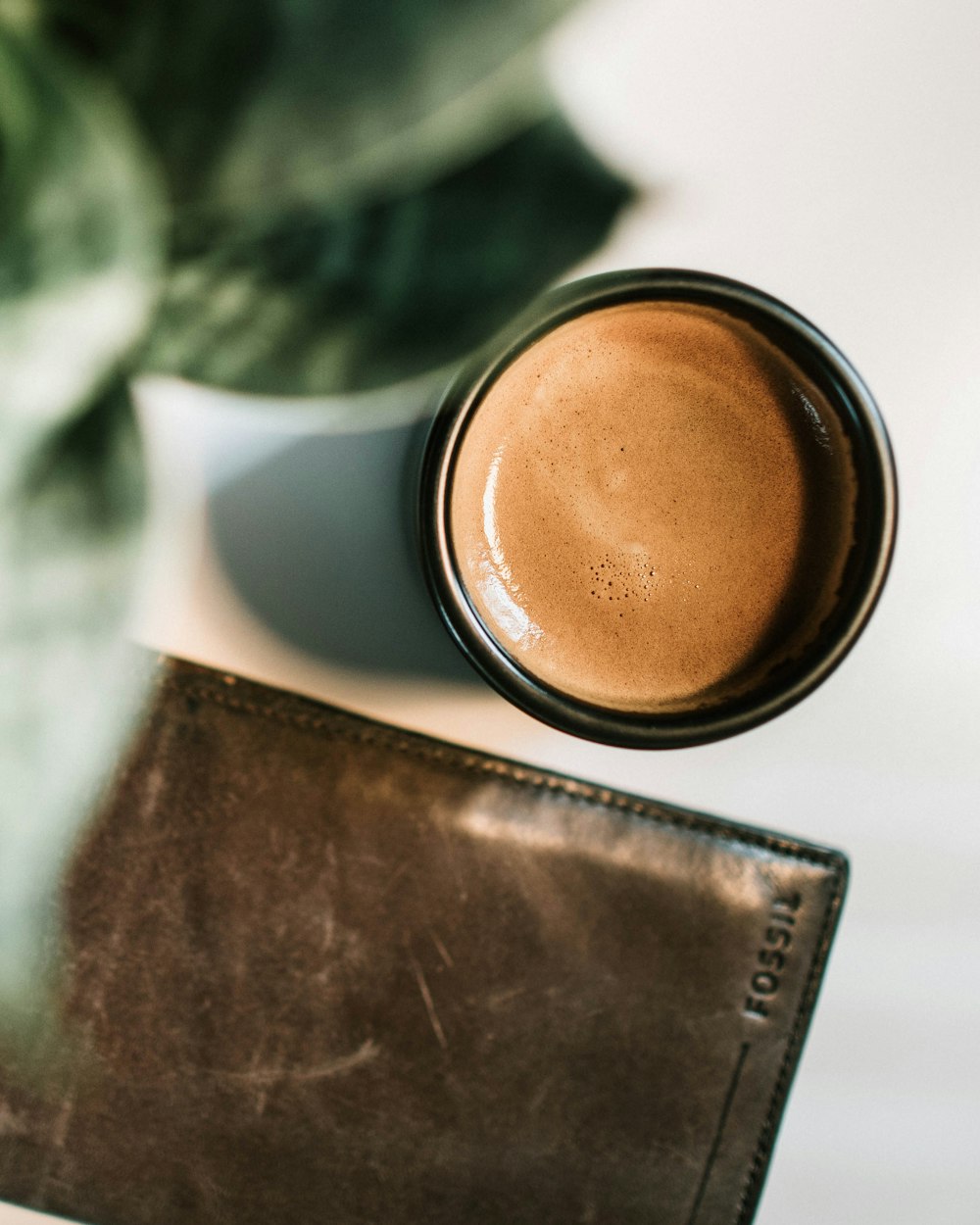 leather wallet near cosmetic jar