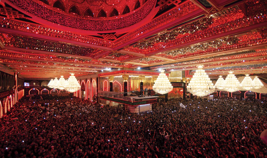 A vibrant crowd applauding during the opening night gala under golden lights.
