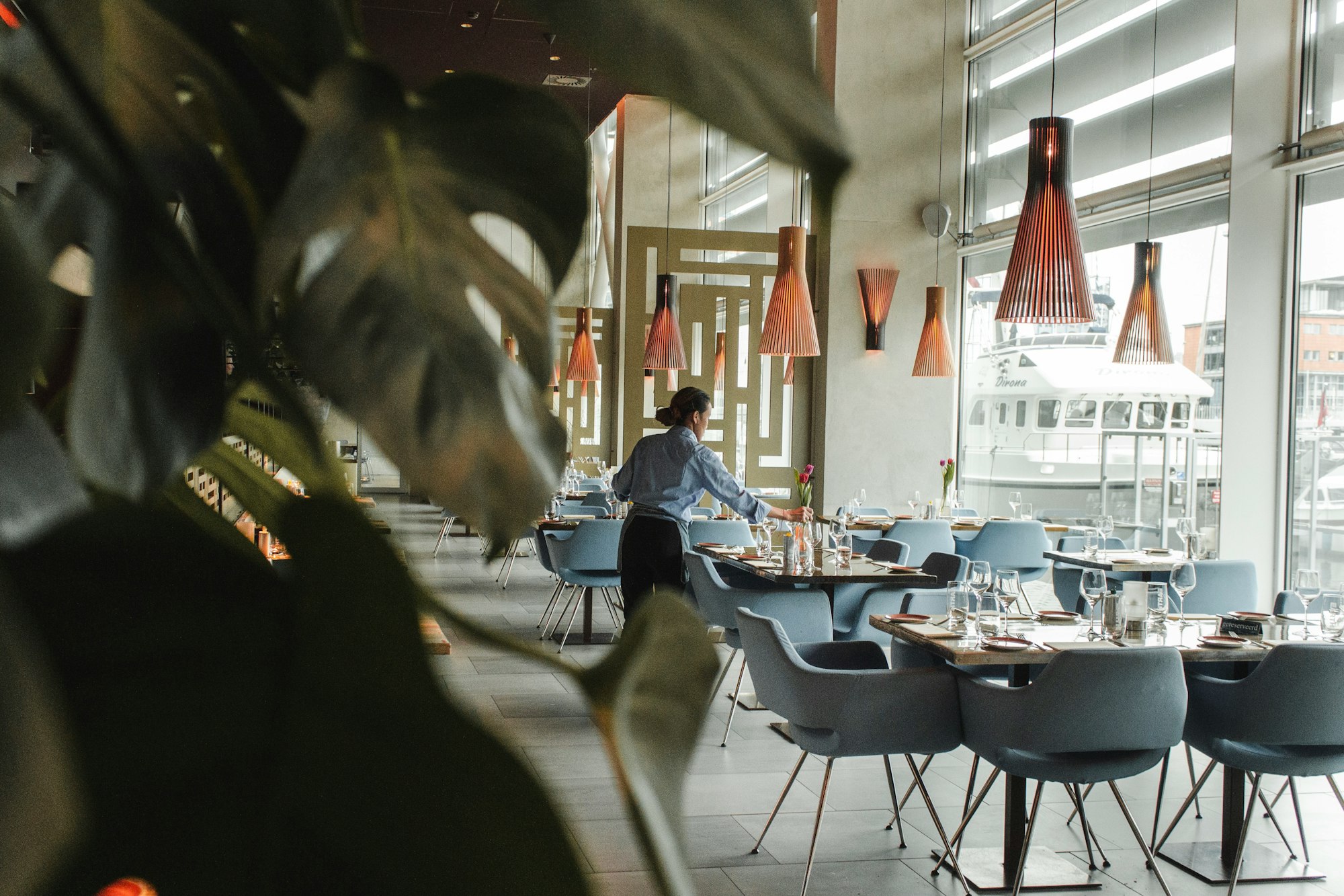 Restaurant waitress preparing reserved table on a waitlist for restaurant guests.