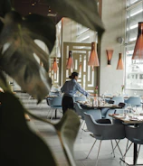 woman in front on brown dining table and chairs inside building