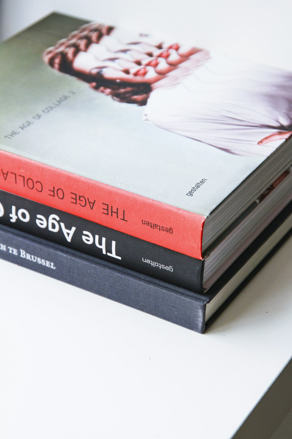 three assorted title books on top of white surface