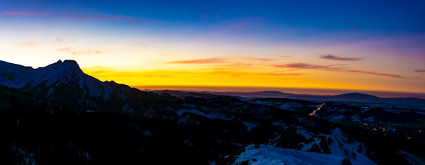 A panoramic view of a mountain range during sunset.