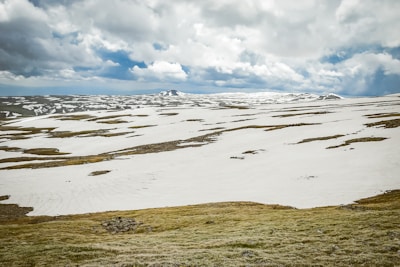 A panoramic view of a sprawling game world featuring diverse biomes and weather effects.