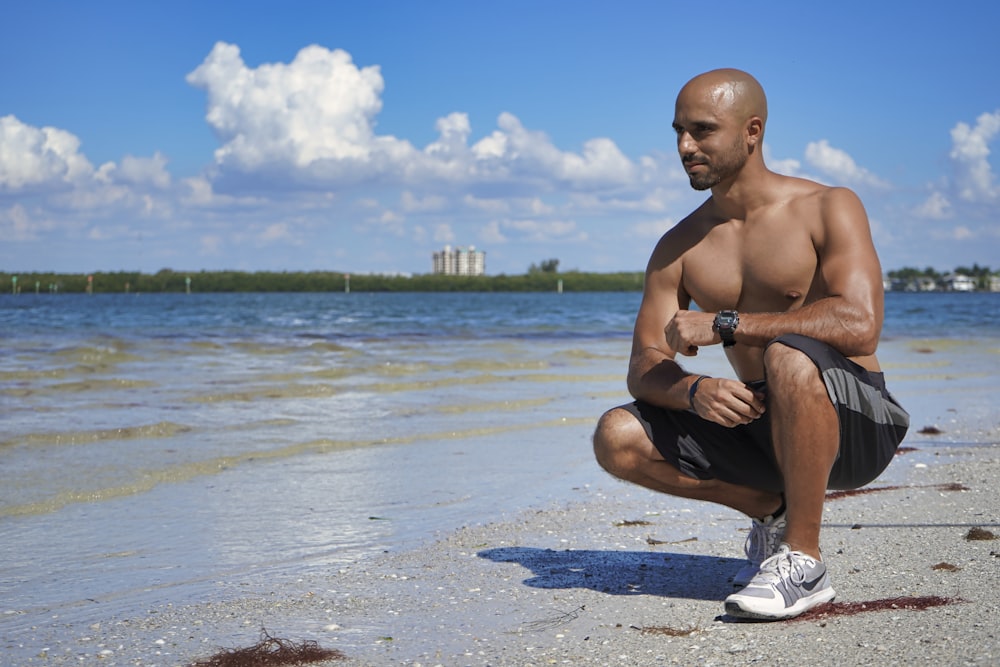 man sitting down beside seashore