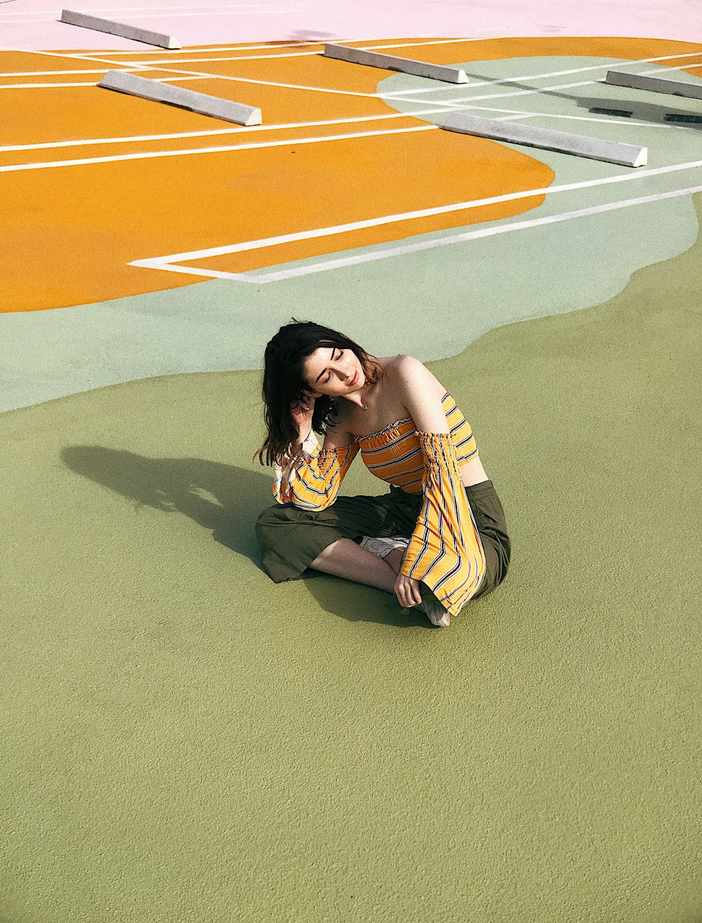 selective focus photography of yellow-and-black striped crop-top and brown pants sitting on field