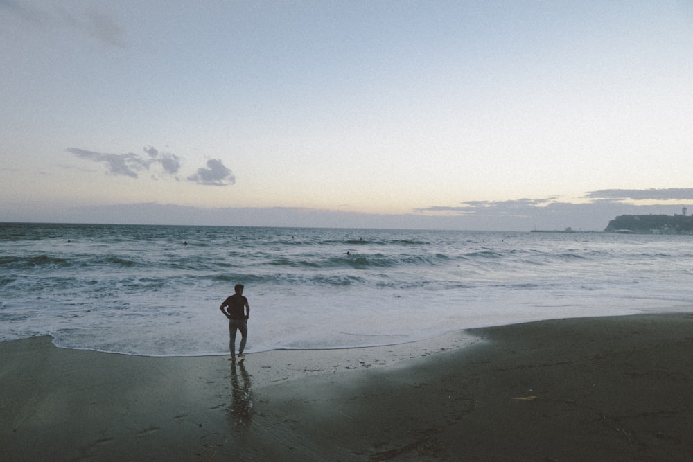 Mann steht am Strand